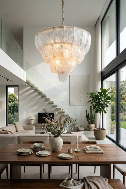 Elegant cascading glass chandelier near staircase | Metal, Glass | High-ceiling living room interior with modern decor | vexa lamps