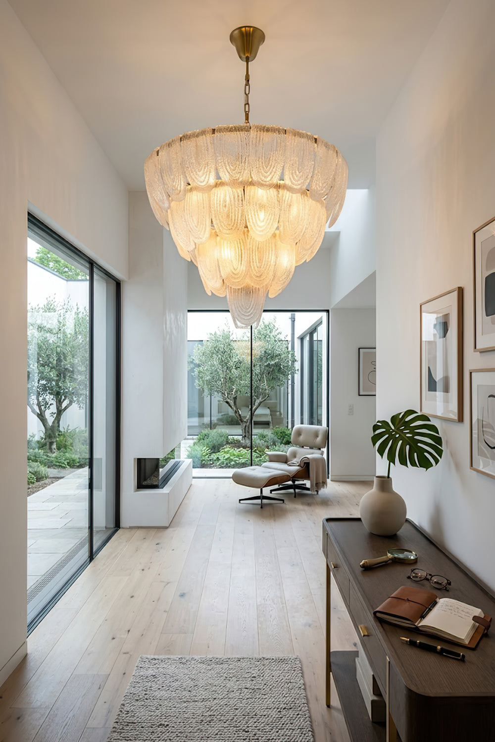 Glass petal chandelier at the end of a corridor | Metal, Glass | Installed in a bright hallway over a wooden console | vexa lamps