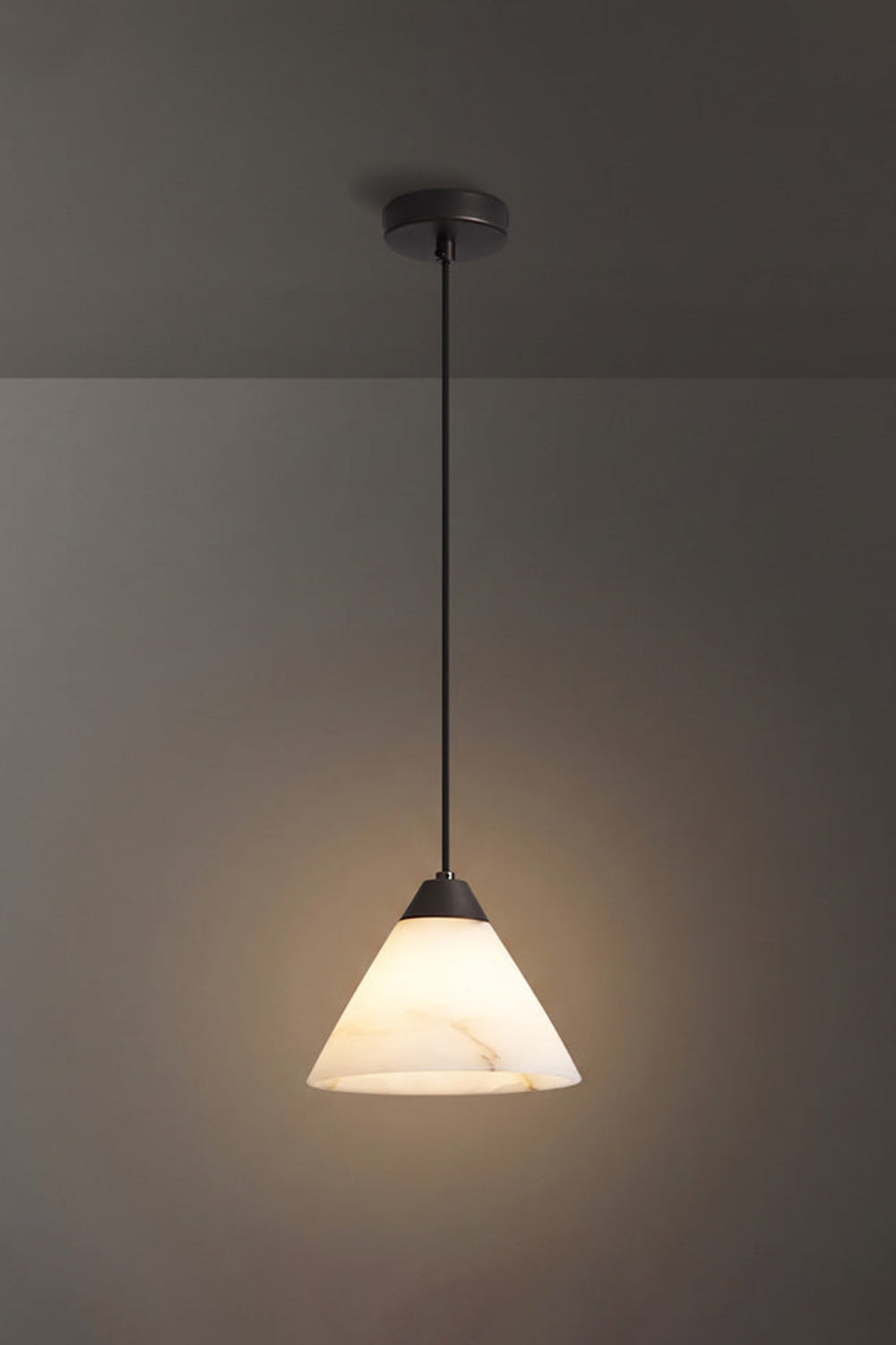Caspian Conical Alabaster Pendant Light | Natural Alabaster and Black Metal | Full studio view of the illuminated cone fixture featuring a matte black rod option | vexa lamps