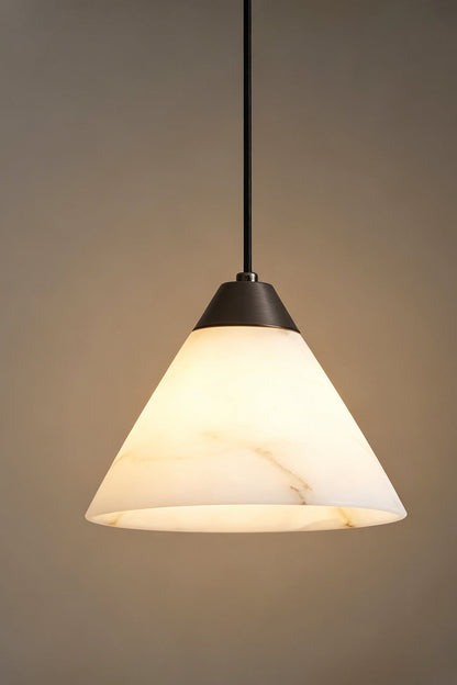 Caspian Conical Alabaster Pendant Light | Natural Alabaster and Brass | Studio view of the conical stone fixture fully illuminated against a warm grey gradient background | vexa lamps
