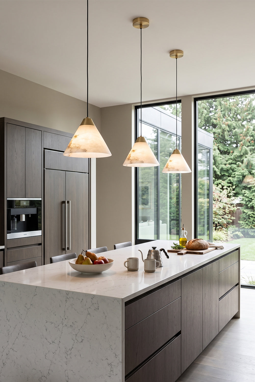 Caspian Conical Alabaster Pendant Light | Natural Alabaster and Brass | A row of three pendants illuminating a modern kitchen island with a clean marble counter | vexa lamps