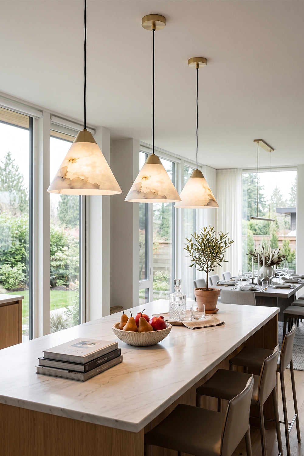 Caspian Conical Alabaster Pendant Light | Natural Alabaster and Brass | Multiple fixtures lined up nicely above a long kitchen bar dining table near large windows | vexa lamps