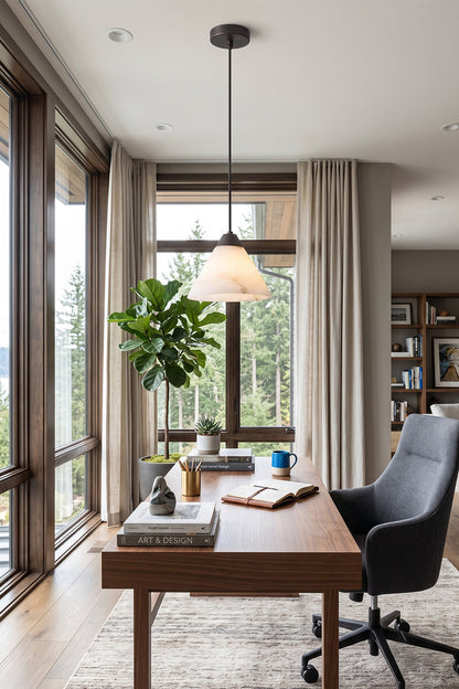 Caspian Conical Alabaster Pendant Light | Natural Alabaster and Brass | Positioned over an elegant wooden desk with a black leather chair looking out a scenic window | vexa lamps