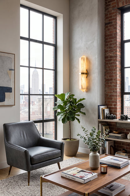 Cassian Faceted Alabaster Wall Sconce illuminating a stylish living room with a view, featuring modern decor and natural elements.