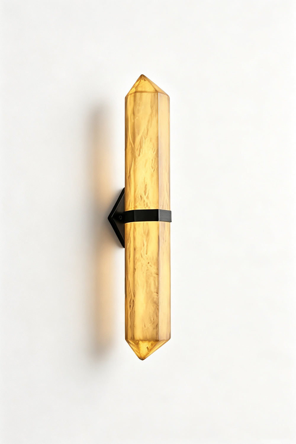 Cassian Faceted Alabaster Wall Sconce features a double-pointed alabaster column with a brass-toned bracket on a white background.