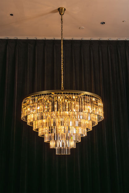 Cassian Tiered Prism Ring Chandelier | Clear Prism Glass and Brass | Full illuminated view displayed against a dark green curtain backdrop | vexa lamps