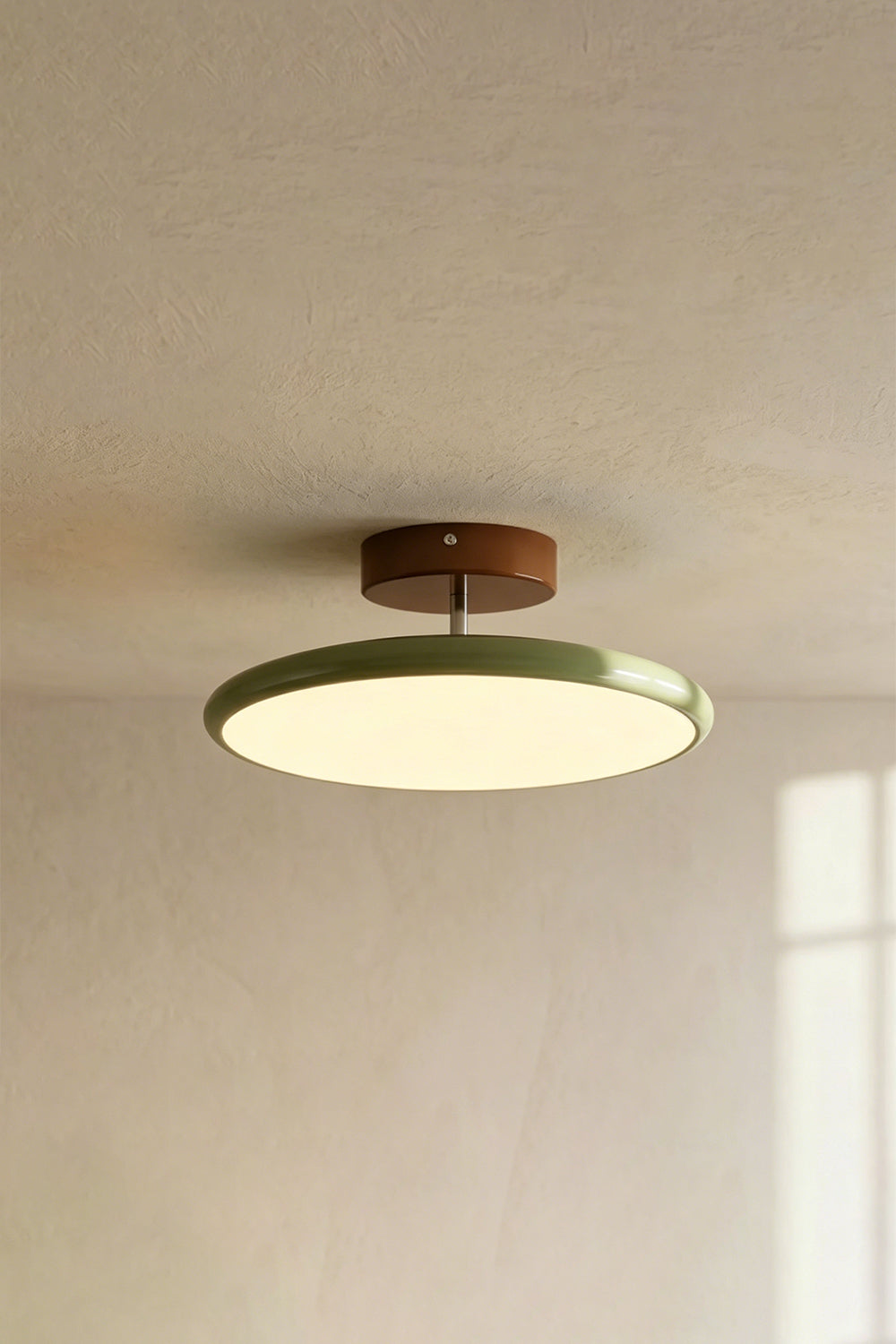 Celestial Disc Lacquered Ceiling Light | Acrylic, Metal | Angled side-profile view of the unlit green-trimmed light on a grey wall, showing depth | Detail shot | vexa lampsCelestial Disc