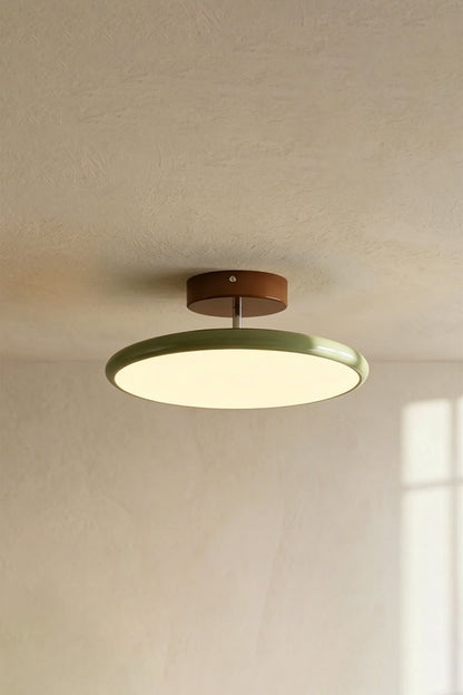 Celestial Disc Lacquered Ceiling Light | Acrylic, Metal | Angled side-profile view of the unlit green-trimmed light on a grey wall, showing depth | Detail shot | vexa lampsCelestial Disc