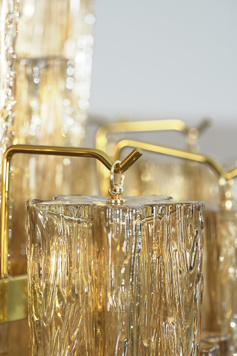 Close-up of the Celestial Glass Cascade Chandelier highlighting fluted glass tubes and gold accents.
