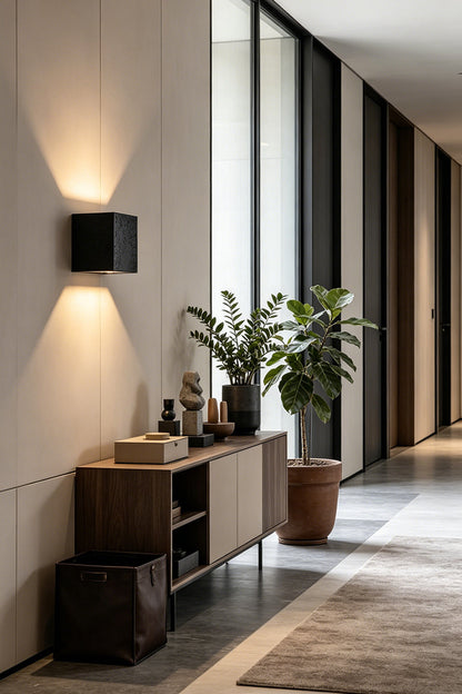 Celestial Tectonic Black Travertine Wall Lamp | Black Travertine | Placed in a gallery hallway near a wooden console | vexa lamps
