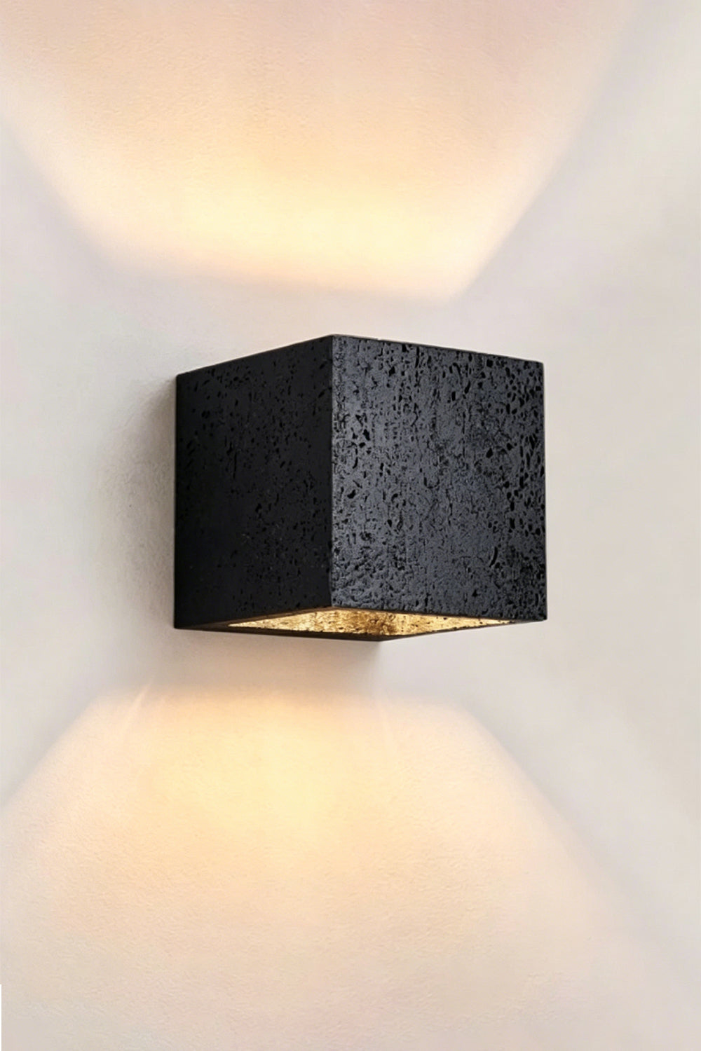 Celestial Tectonic Black Travertine Wall Lamp | Black Travertine | Angled perspective showing stone surface and warm glow | vexa lamps