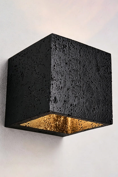 Celestial Tectonic Black Travertine Wall Lamp | Black Travertine | Lit lamp on neutral wall showing symmetric light beams | vexa lamps