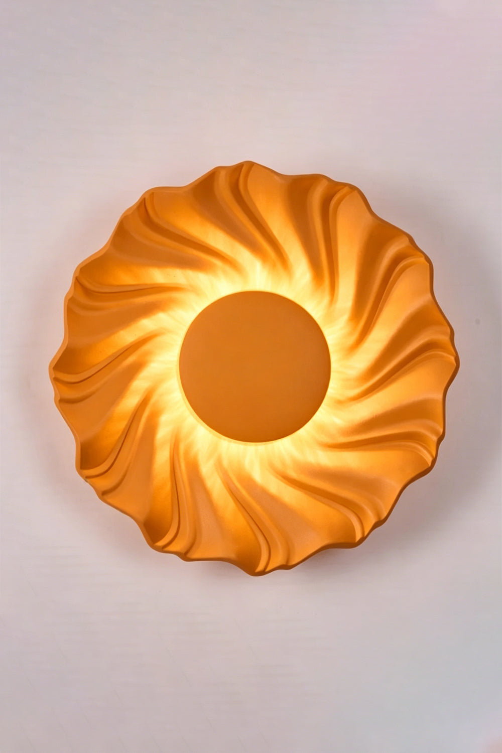 Centripetal Solstice Metal Wall Lamp | Metal, Resin | Orange textured lamp on a plain background, providing warm light | Isolated lit variant shot | vexa lamps