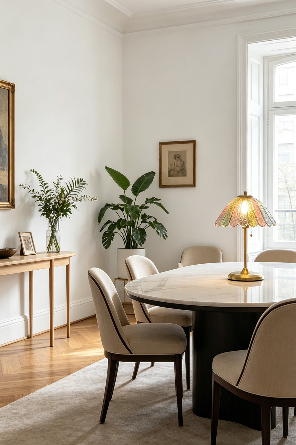 Clara Vintage Pastel Glass Table Lamp | Glass, Metal | Serving as an elegant centerpiece on a large round wooden dining table surrounded by cream chairs | vexa lamps