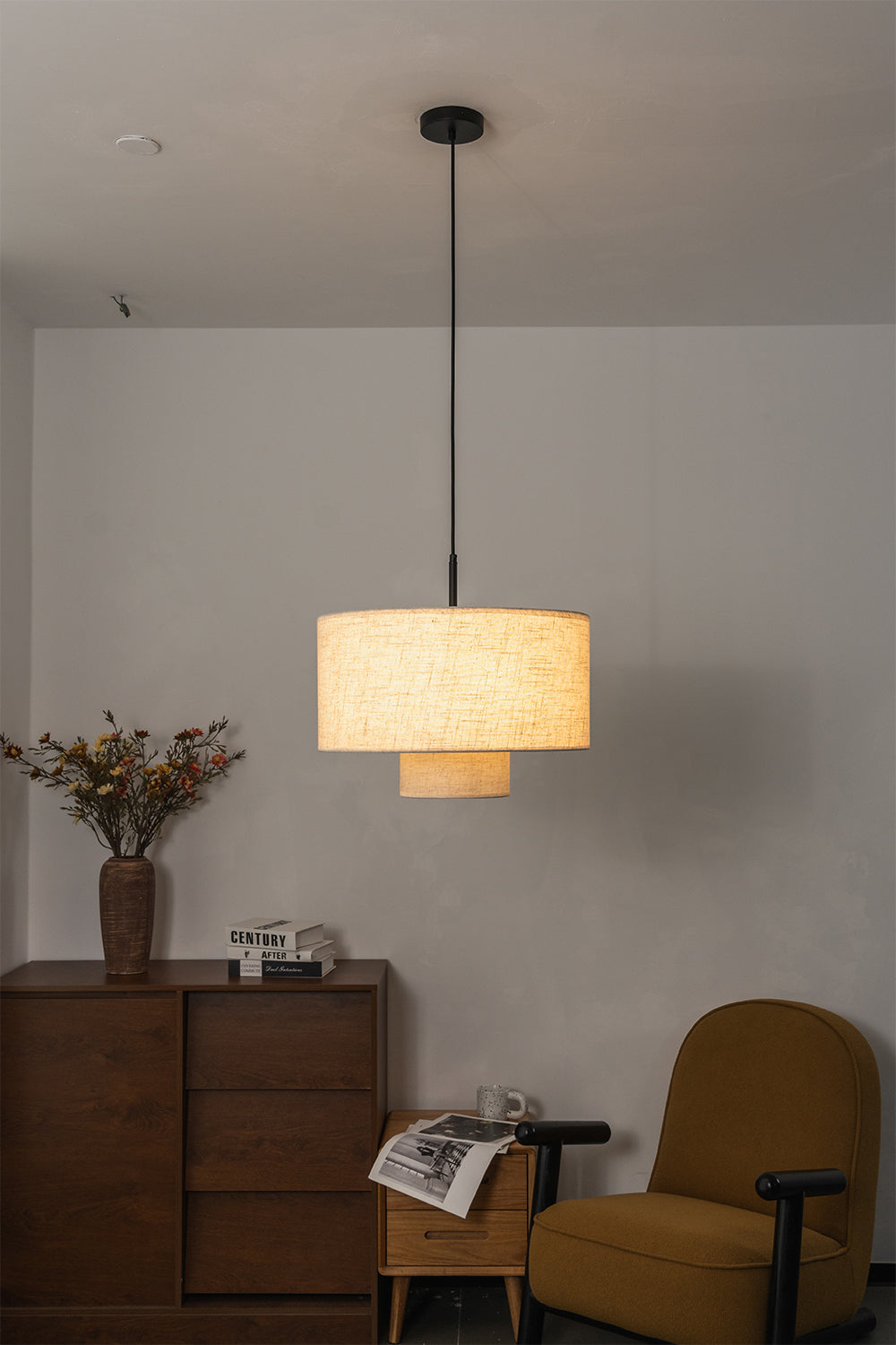 Concentric Veil Fabric Pendant Light | Fabric | Lit pendant near an armchair and wooden chest of drawers | vexa lamps