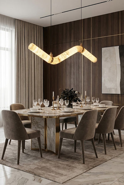 Undulating alabaster tube pendant light | Alabaster, Brass | Installed over a large dining table with upholstered chairs | vexa lamps