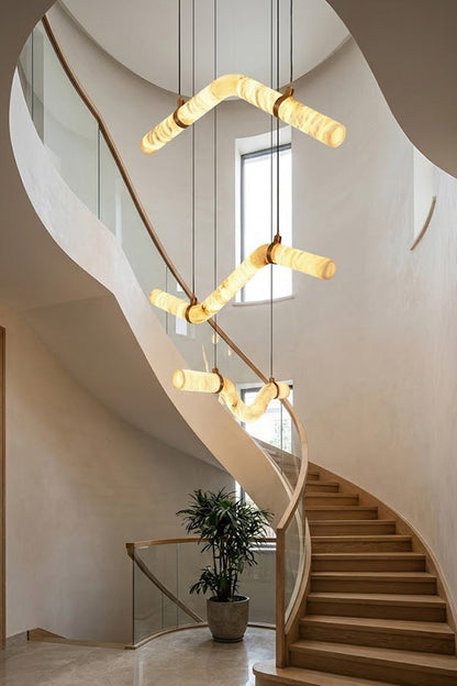 Multiple undulating alabaster tubes in a spiral staircase | Alabaster, Brass | High-ceiling void installation view | vexa lamps