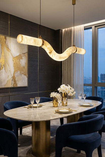 Undulating alabaster tube chandelier over marble table | Alabaster, Brass | Elegant dining room with blue velvet chairs | vexa lamps