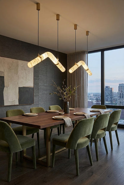 Modern undulating alabaster light fixture | Alabaster, Brass | Centered in a bright dining room with large windows | vexa lamps