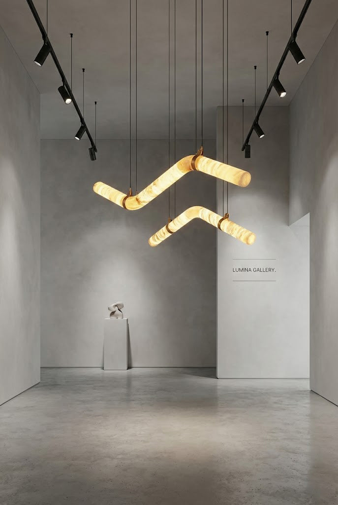 Undulating alabaster tube chandelier in minimalist gallery | Alabaster, Brass | Artistic installation over a pedestal | vexa lamps