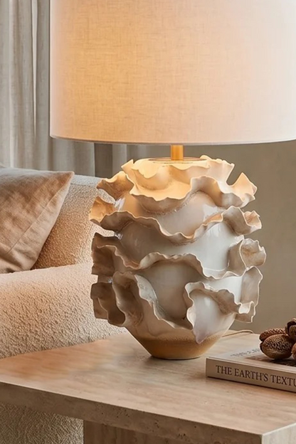 Coralia Ruffled Ceramic Table Lamp with organic wave-like details on a living room table.
