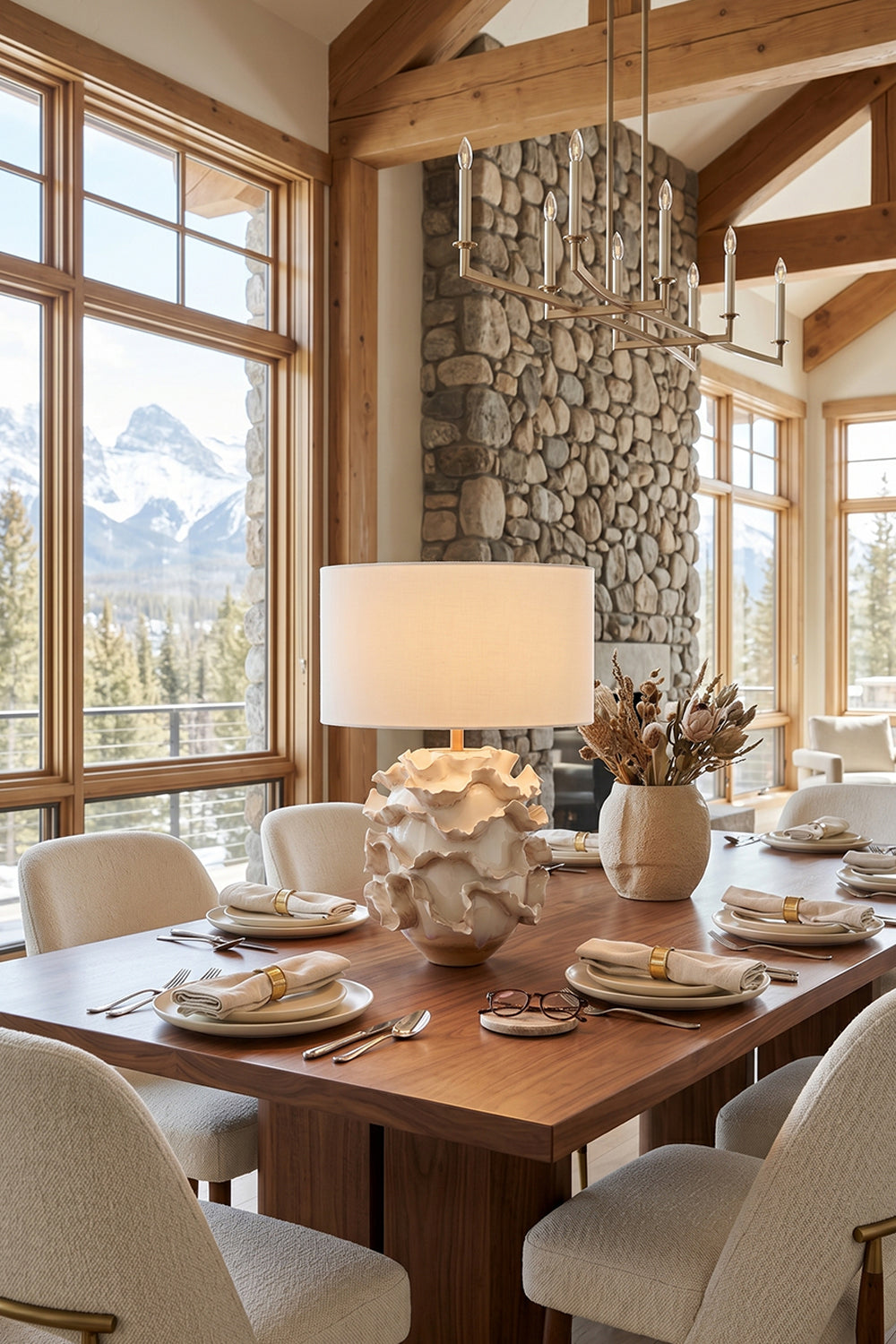 Coralia Ruffled Ceramic Table Lamp placed on a wooden dining table, with elegant plates and a scenic mountain view.