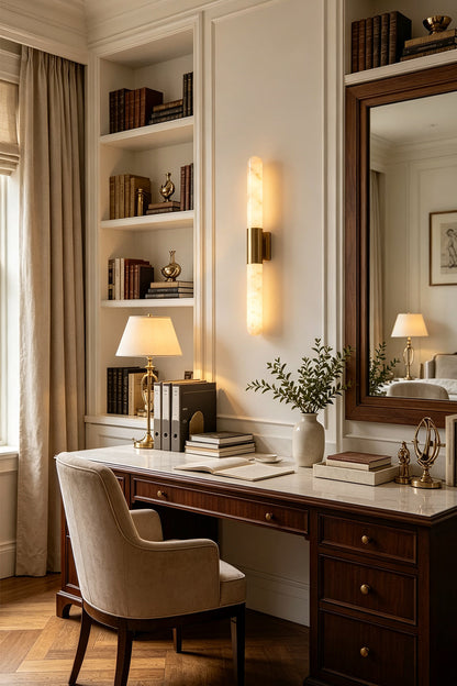 Corin Linear Alabaster Wall Sconce illuminating a stylish desk in a cozy home office setting.