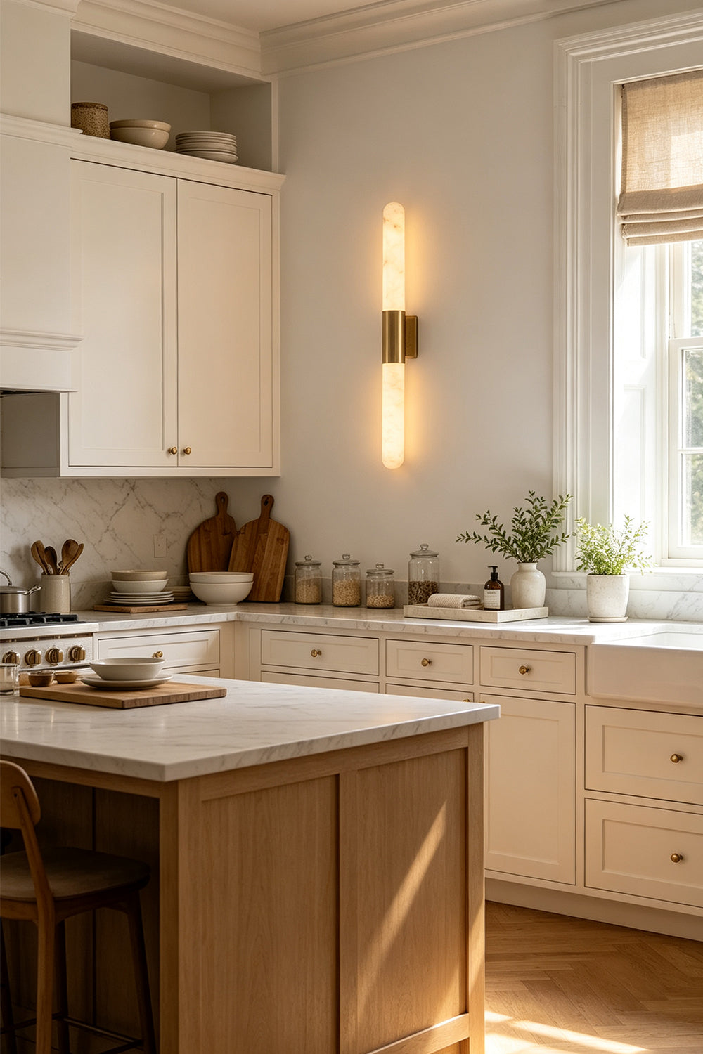 Corin Linear Alabaster Wall Sconce illuminating a modern kitchen with white cabinetry and warm tones.