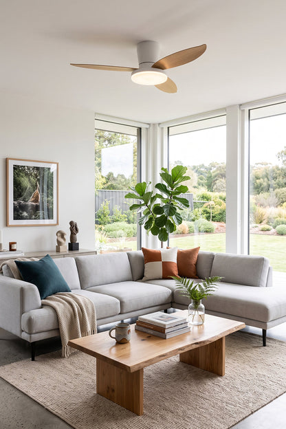Corin Low-Profile Ceiling Fan Light illuminating a modern living space with a gray sofa and wooden coffee table.