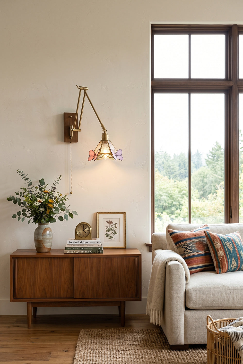 Cynthia Butterfly Articulated Wall Lamp | Stained Glass, Metal, Wood | Providing warm accent light above a mid-century wooden sideboard credenza next to a cream fabric sofa | vexa lamps