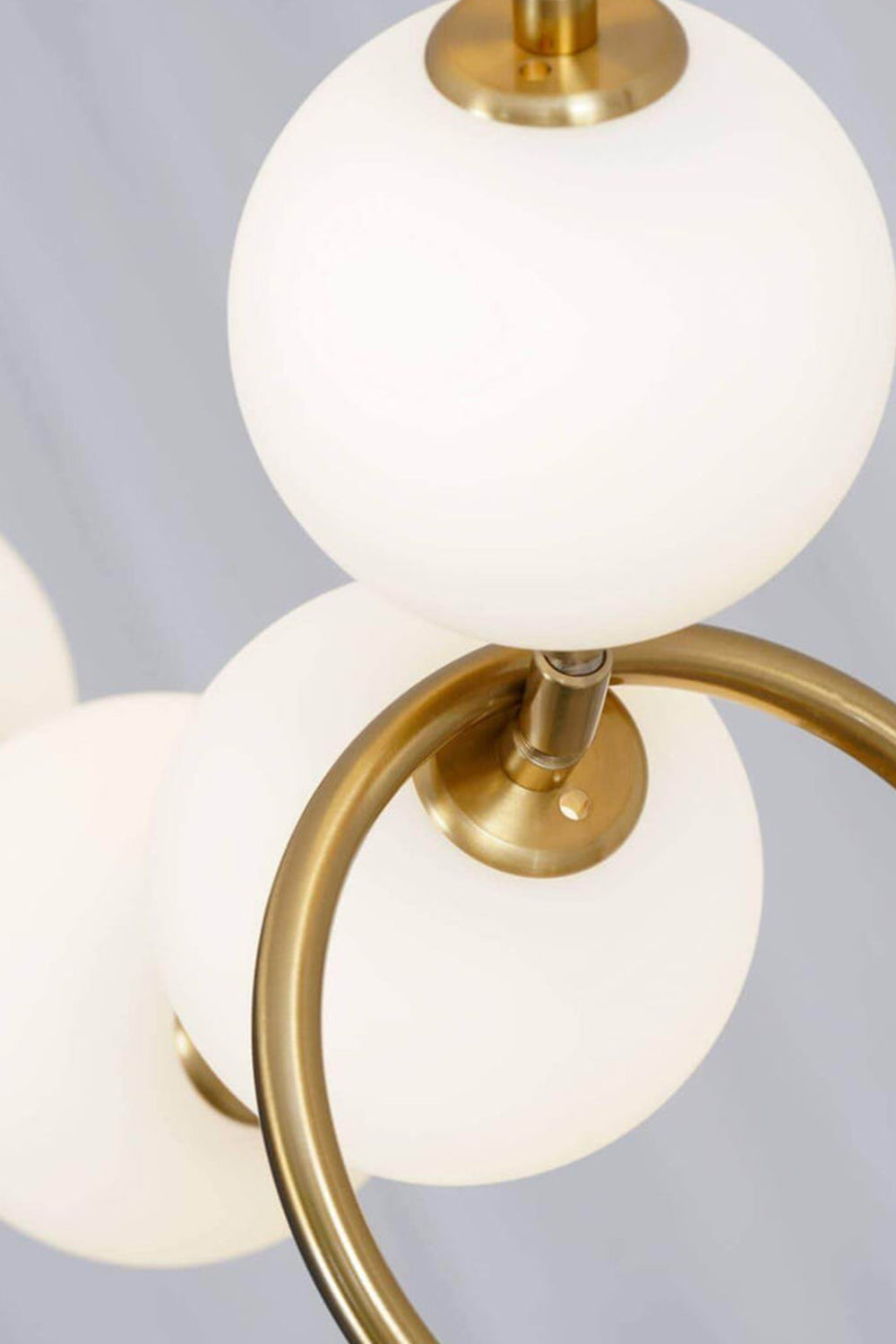 Delphine Pearl Strand Chandelier featuring matte-white globes and brass-toned accents.