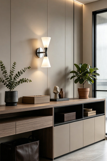 Diabolo Symmetry Glass Wall Sconce illuminating a modern living space with elegant decor and plants.