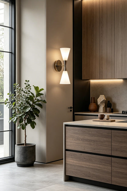 Diabolo Symmetry Glass Wall Sconce illuminating a modern kitchen with wood and marble elements.