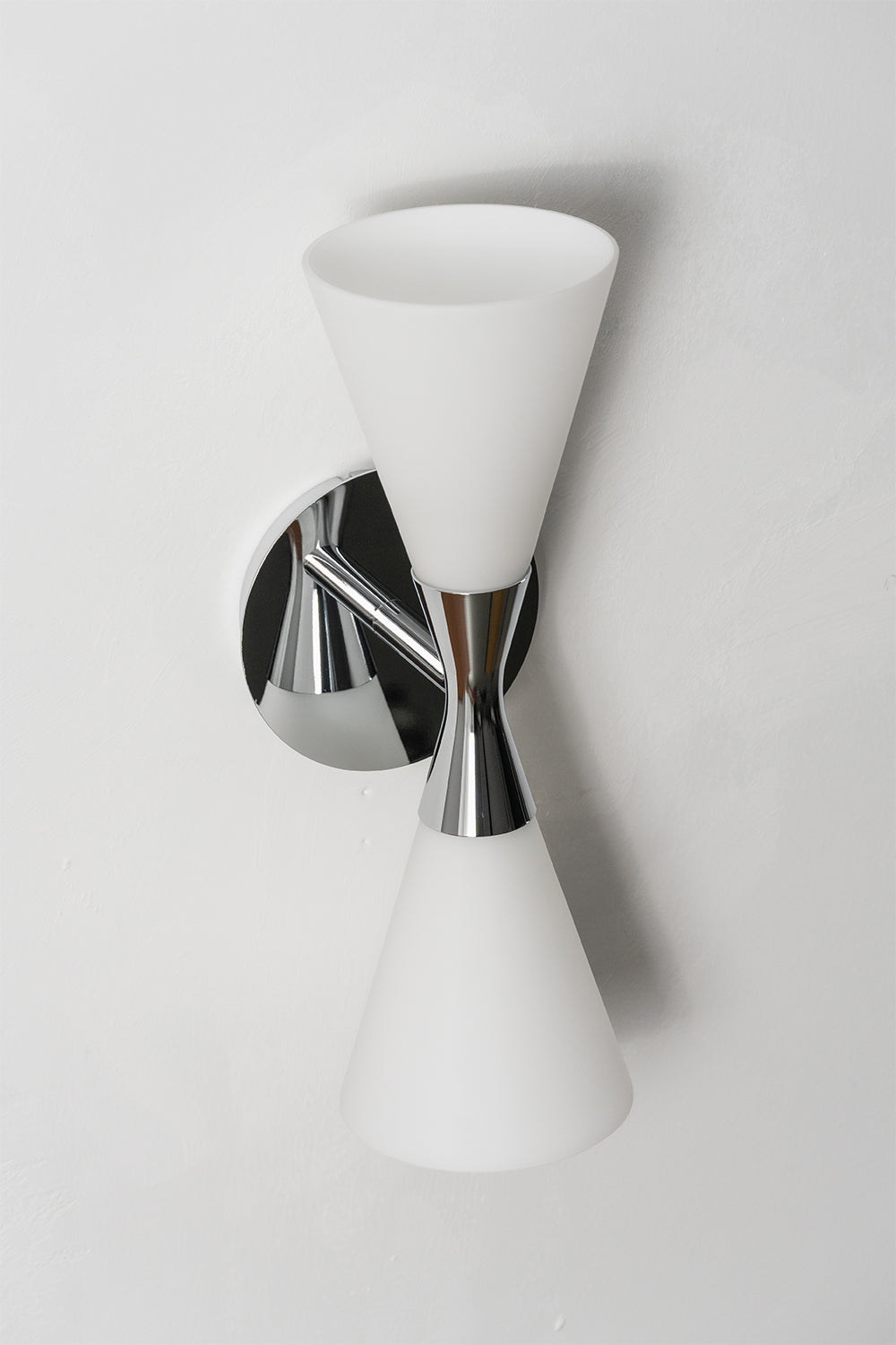 Diabolo Symmetry Glass Wall Sconce showcasing dual conical glass shades mounted on a sleek chrome fixture.