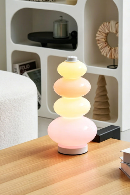 Dolce Stacked Pastel Glass Table Lamp | Glass, Metal | Styled on a smooth wooden coffee table in a contemporary lounge area with white bouclé furniture | vexa lamps