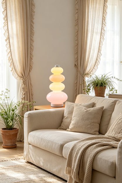 Dolce Stacked Pastel Glass Table Lamp | Glass, Metal | Illuminating a serene living room corner from a side table next to a comfortable beige fabric sofa | vexa lamps