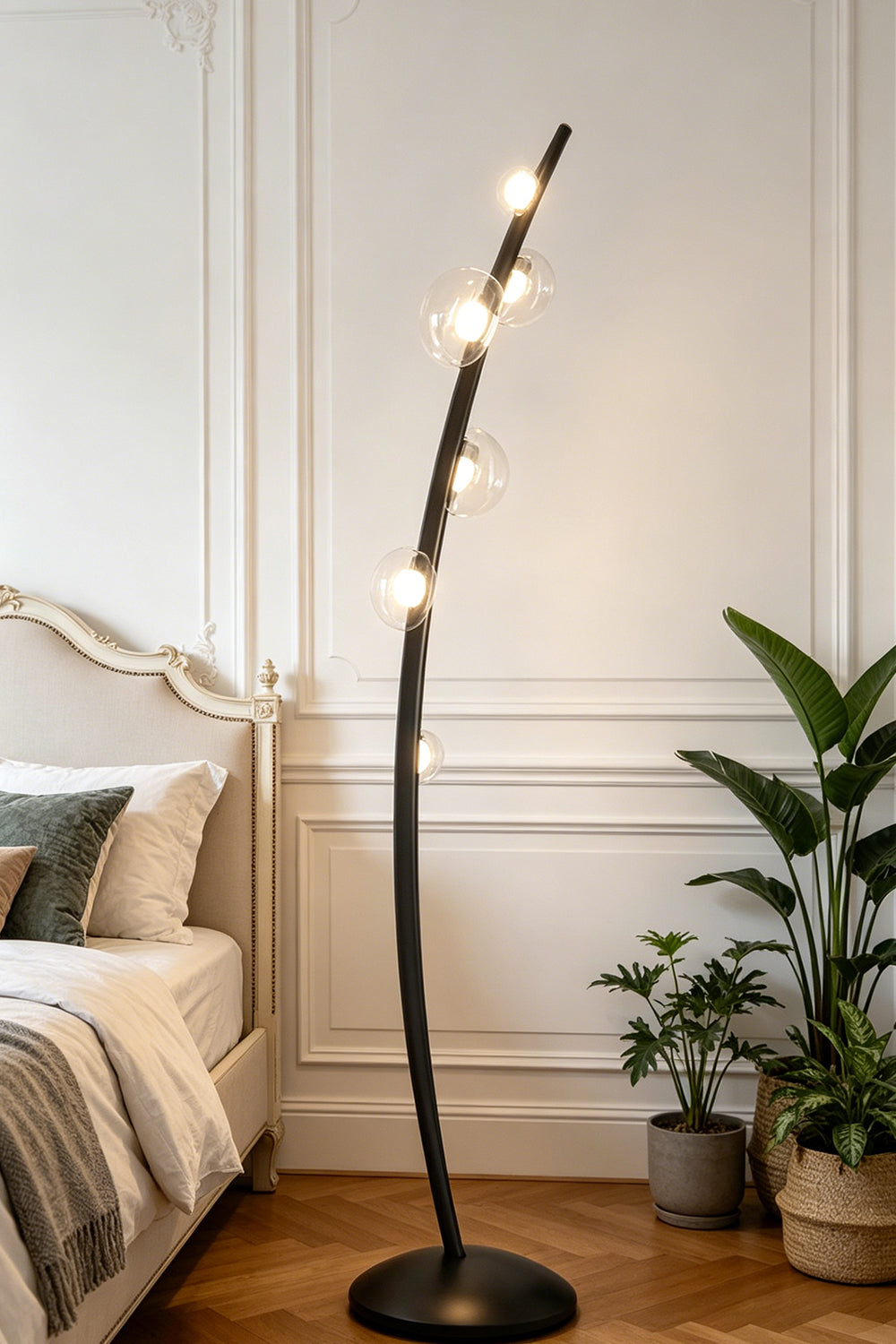 Drosia Dewdrop Floor Lamp | Glass, Metal | Standing elegantly as a modern reading light in a cozy bedroom corner next to a platform bed and indoor potted plants | vexa lamps