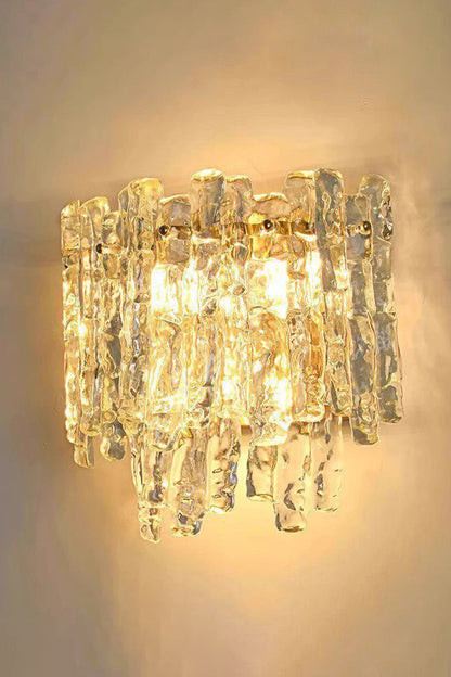 Elara Textured Cast Glass Wall Lamp | Textured Cast Glass, Polished Brass | Fully illuminated view, showing the mesmerizing, undulating, and warm light pattern cast onto the adjacent wall, illustrating its dynamic visual effect | vexa lamps