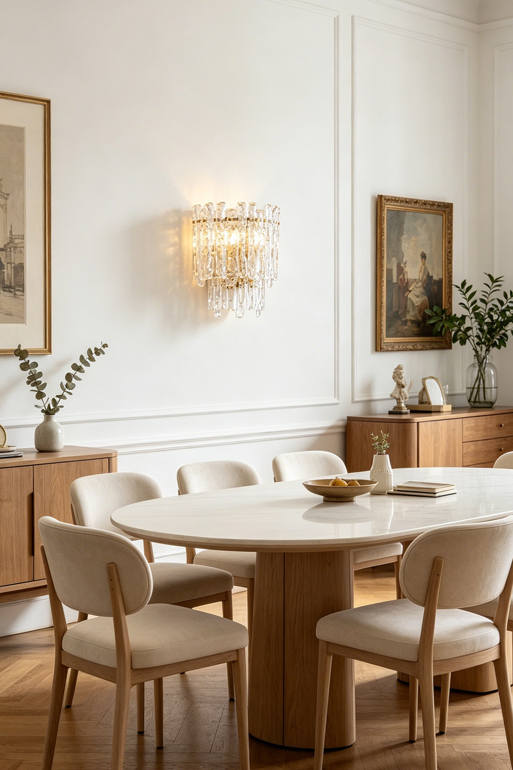 Elara Textured Cast Glass Wall Lamp | Textured Cast Glass, Polished Brass | Set above an oval wooden dining table and matching chairs, creating a sophisticated dining ambiance near a large window and sideboard | vexa lamps