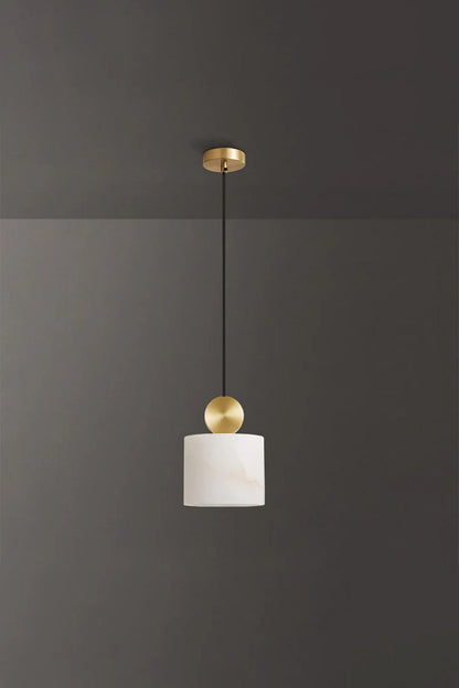 Elian Minimalist Alabaster Pendant Light hanging from the ceiling against a dark background with a gold accent.