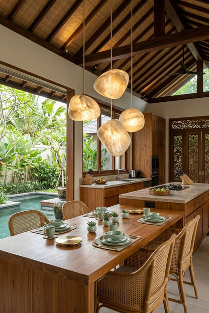 Elodie Teardrop Alabaster Pendant Light illuminating a modern kitchen with wooden decor and natural greenery.