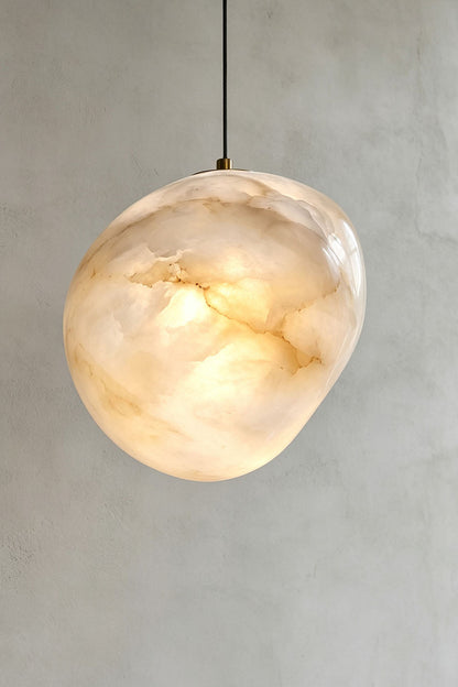 Elodie Teardrop Alabaster Pendant Light hanging from the ceiling, showcasing its organic shape and unique design.