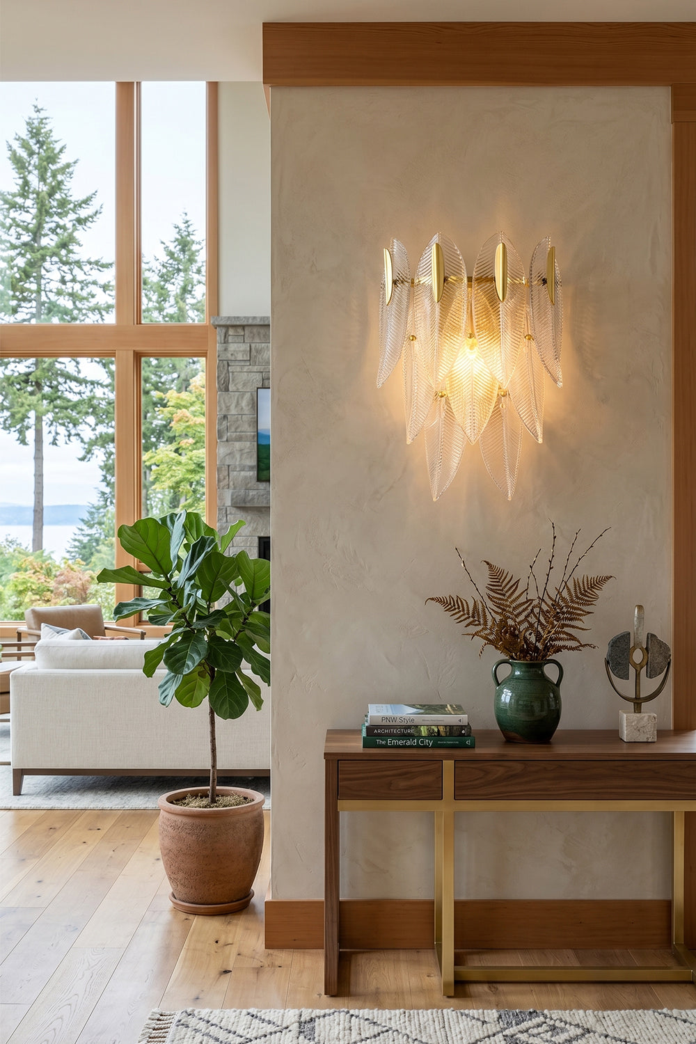 Elowen Cascading Glass Wall Lamp | Glass, Metal | Positioned elegantly on a pillar wall in a modern open-concept living space next to a wooden console table and a green potted plant | vexa lamps