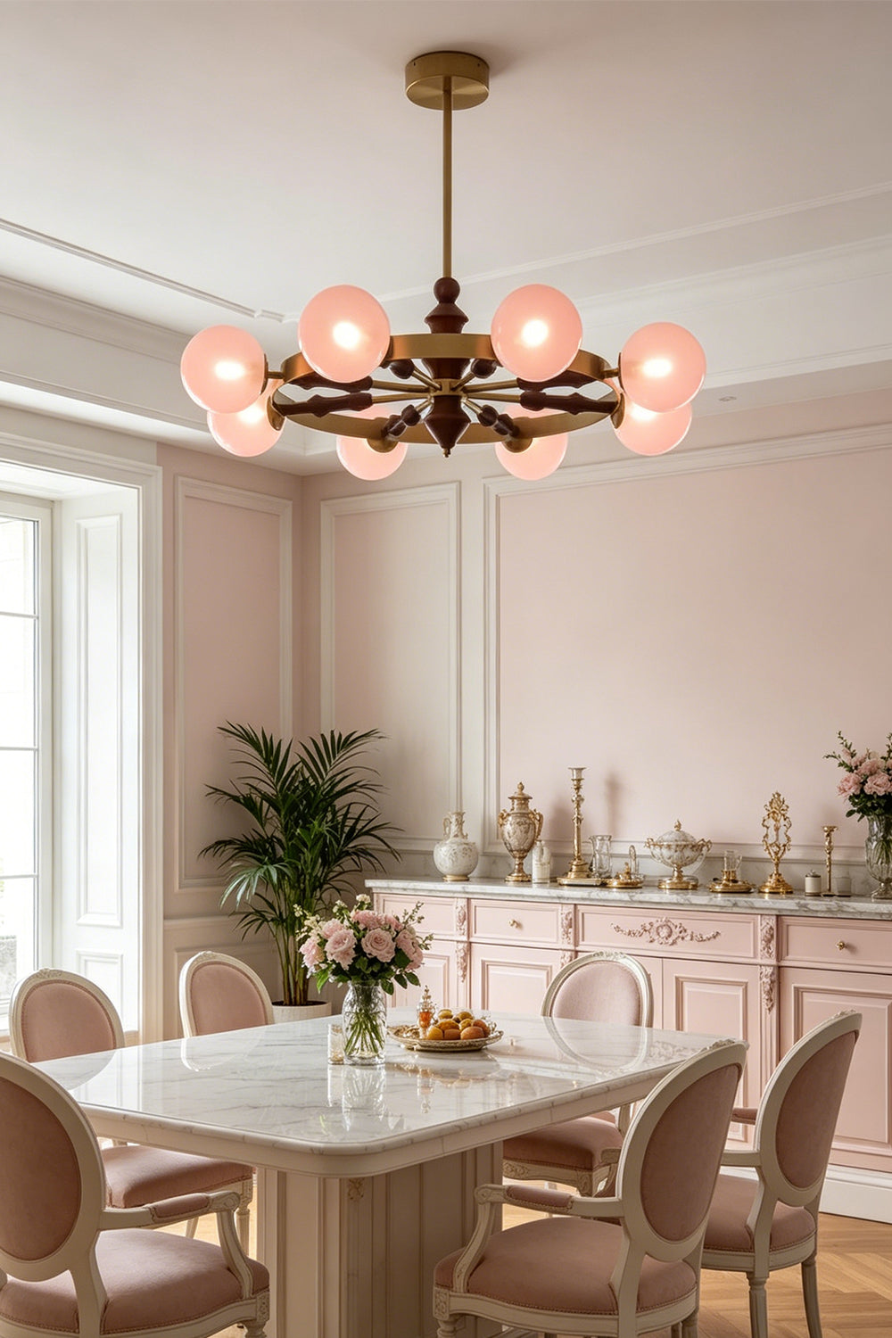 Elysian Circlet Chandelier with pink globes over a dining table | Metal, Glass, Wood | Installed in a modern classic dining room with pink chairs | vexa lamps