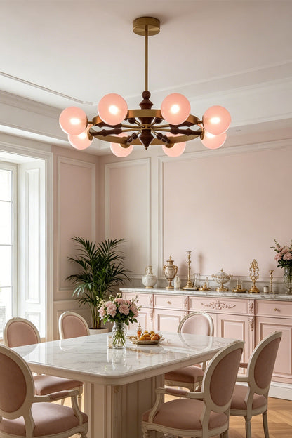 Elysian Circlet Chandelier with pink globes over a dining table | Metal, Glass, Wood | Installed in a modern classic dining room with pink chairs | vexa lamps