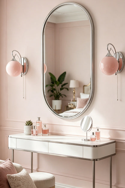 Pair of pink glass globe sconces | Metal, Glass | Vanity flanking oval mirror in soft pink room | vexa lamps