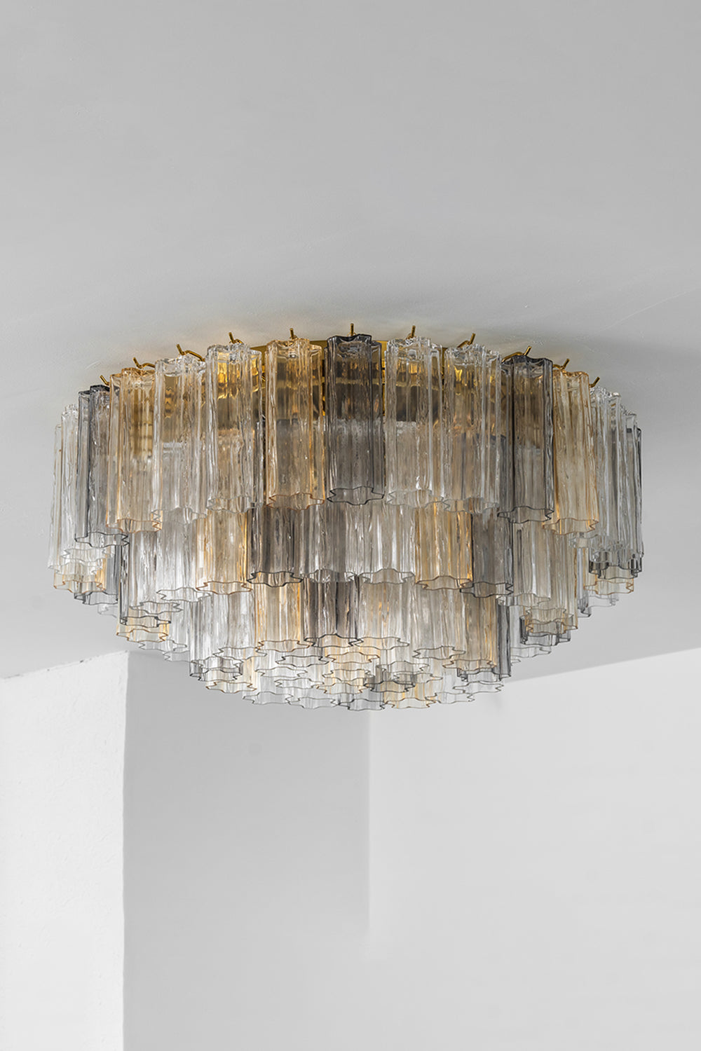 Elysian Tiered Fluted Ceiling Light | Glass, Metal | Unlit corner view of the tiered glass flush mount showcasing the clear texture of overlapping rods and a gold canopy base | vexa lamps