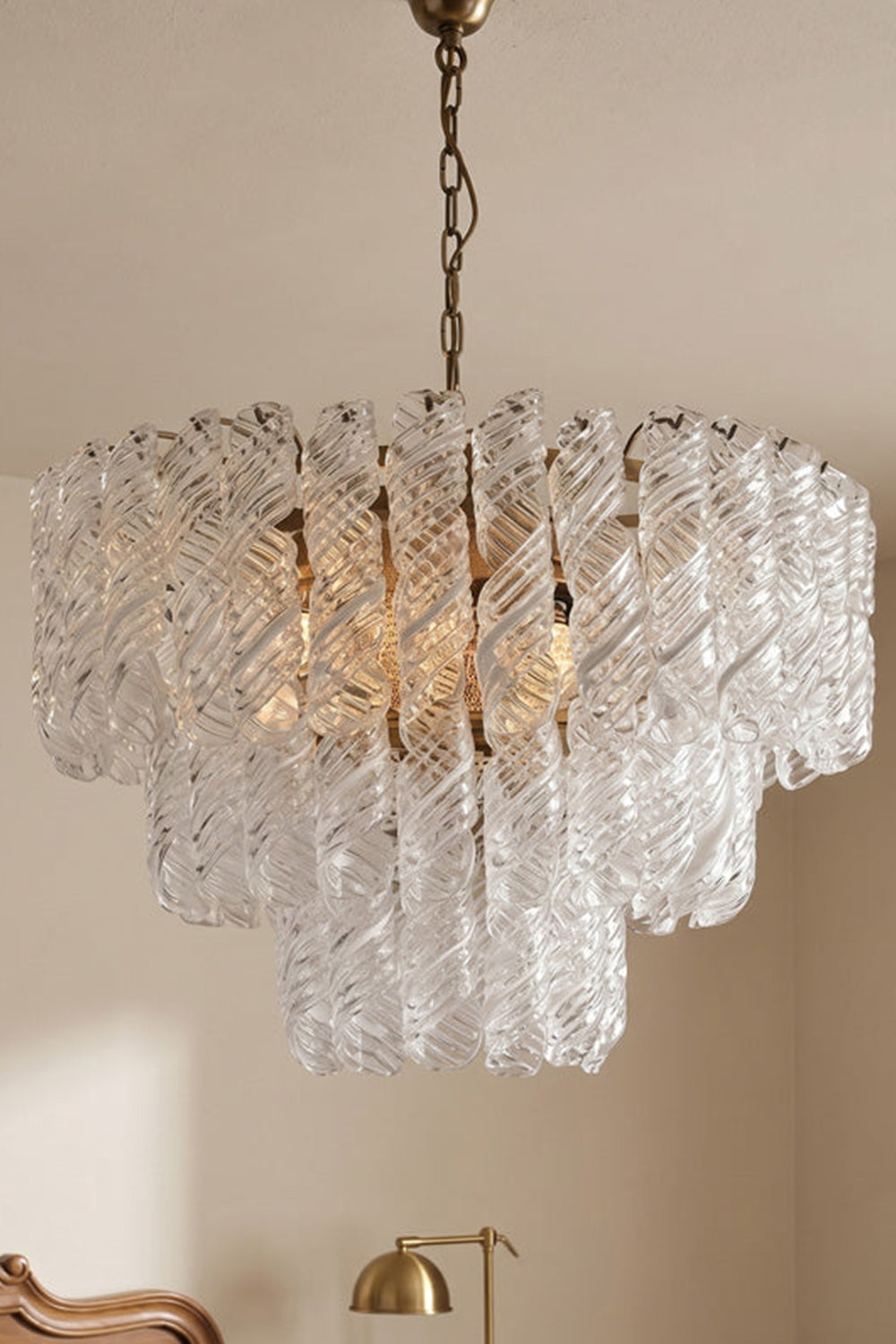 Evangeline Tiered Twisted Glass Chandelier | Studio Hanging View | Full-length studio presentation of the cascading tiered glass pendant lamp fixture hanging against a plain wall | vexa lamps