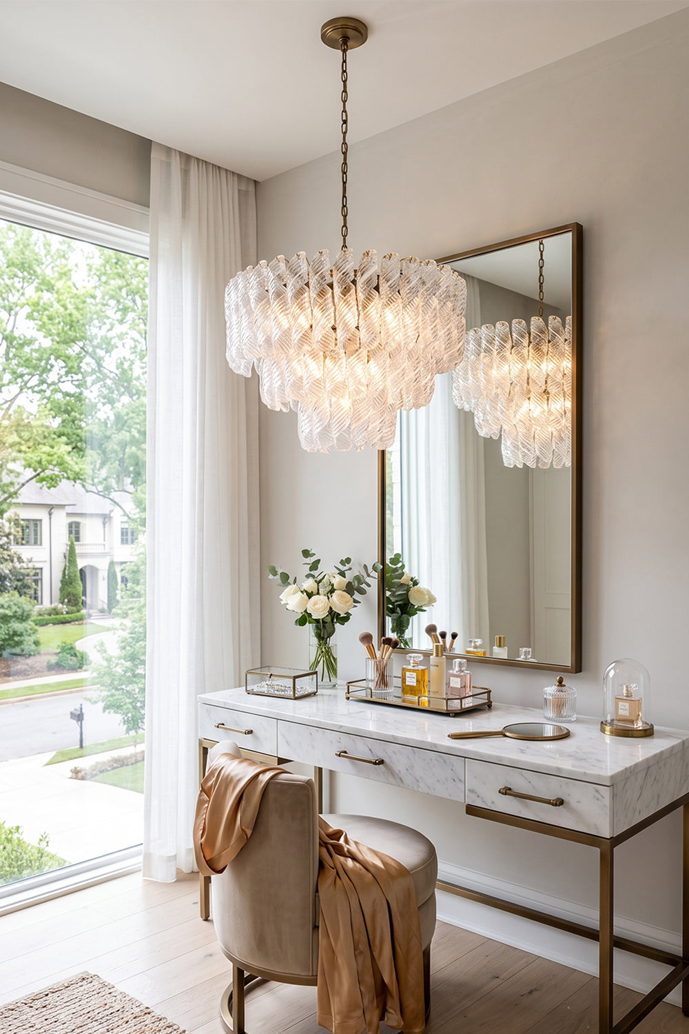 Evangeline Tiered Twisted Glass Chandelier | Dressing Room Decor | Radiating a soft ambient glow next to a white vanity dressing table with a large mirror in a sunlit residential space | vexa lamps