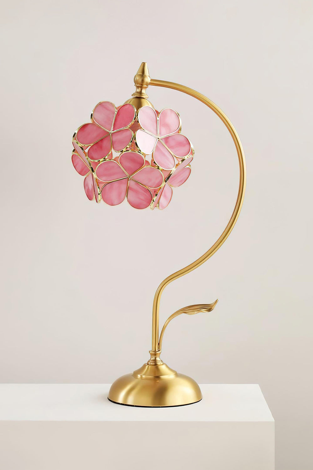 Evanthe Blossom Stained Glass Table Lamp | Stained Glass, Metal | Front view of the fully lit pink blossom table lamp displayed elegantly on a clean white pedestal backdrop | vexa lamps